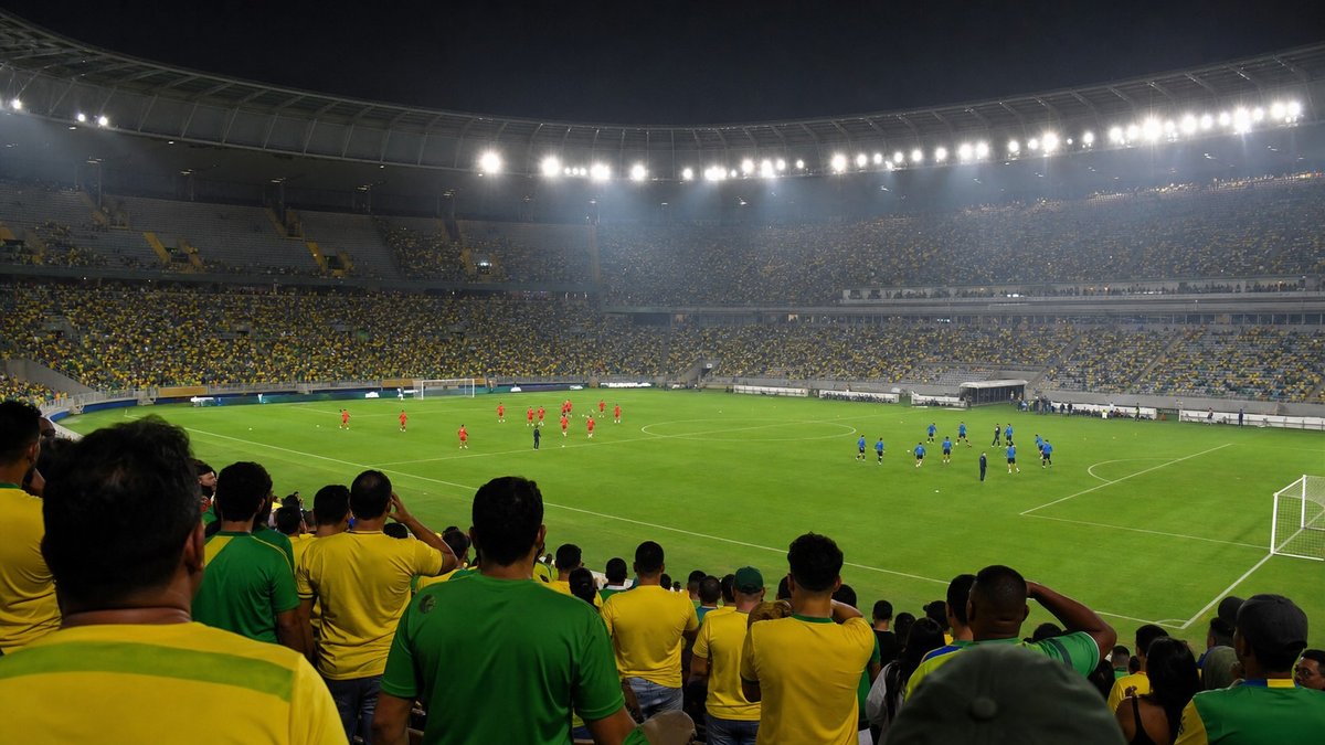 Estádio de futebol iluminado antes de jogo decisivo, com jogadores aquecendo e torcedores atentos nas arquibancadas.