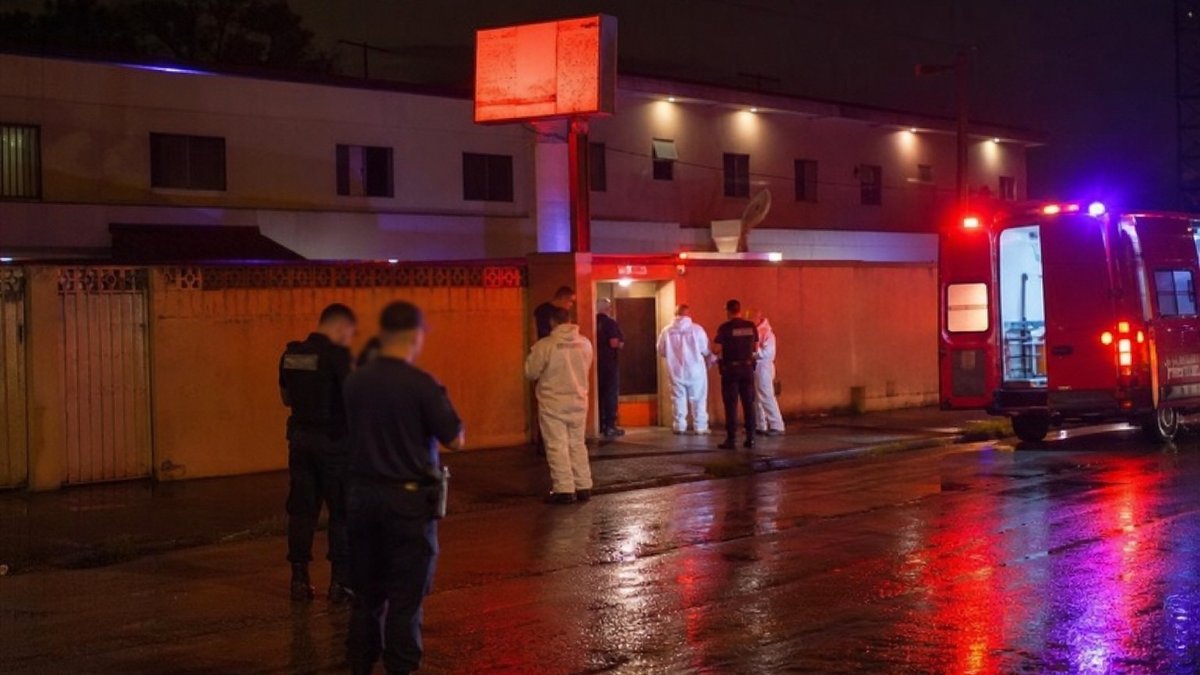 Equipe de investigação em frente a motel durante apuração policial noturna.