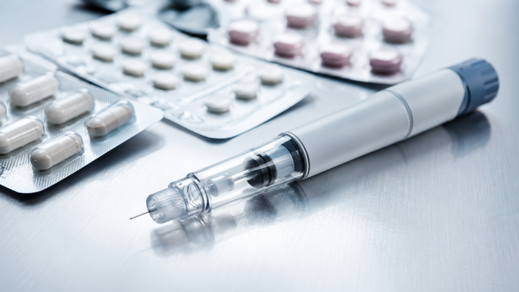 Caneta injetável de medicamento e cartelas sobre superfície clínica — fiscalização sanitária