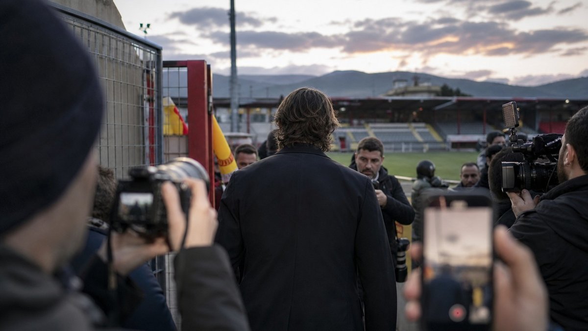Ex-jogador brasileiro chegando a um pequeno estádio italiano diante de câmeras.