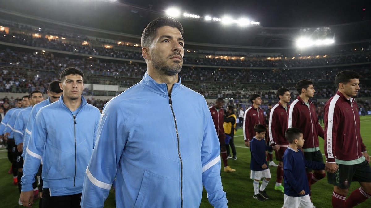 Jogadores de futebol entrando em campo à noite em estádio moderno nos Estados Unidos.
